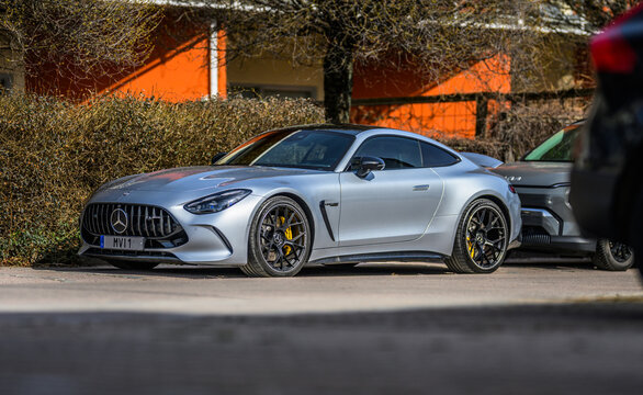 V?ster?s, Sweden - April 18 2026: Sleek silver Mercedes Benz sports car parked in quiet residential street under soft daylight.