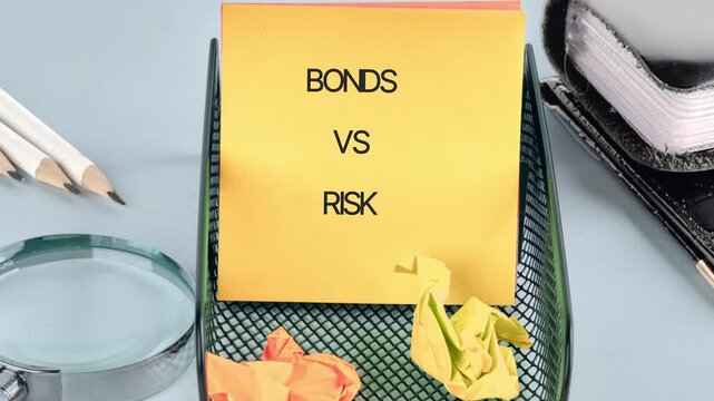 Yellow sticky note displaying Bonds versus Risk in an office desk organizer. Pencils, a magnifying glass, and a notebook are nearby on a light blue surface