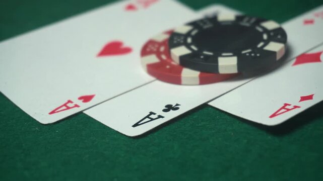 A close-up of playing cards and poker chips on a green felt table, with three aces standing out along with a stack of chips, creating an exciting gaming atmosphere