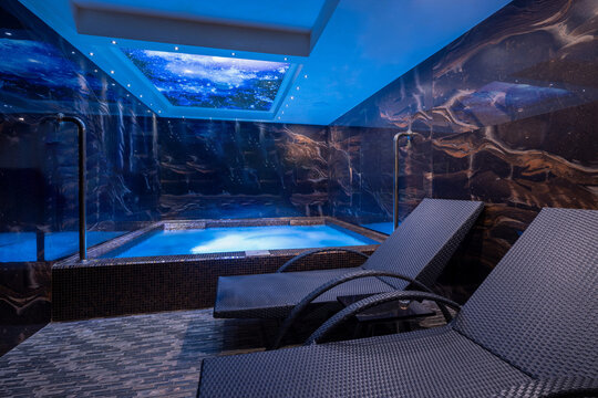 Indoor luxury pool and jacuzzi area with starry sky ceiling design