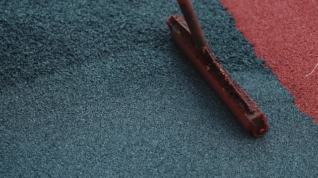 Leveling rubber crumb coating with finishing screed close up