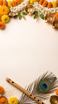 Janmashtami copy space background with flute peacock feather diyas and flower garlands