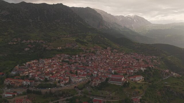 Beautiful aerial view of the traditional village of Arachova nestled on the slopes of mount Parnassus in Greece, with charming houses featuring red-tiled roofs and scenic mountain scenery