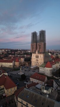 Aerial view of Zagreb Cathedral and the historic Kaptol district. Cinematic drone shot of the Gothic spires and the medieval walls of the Cathedral of the Assumption of the Blessed Virgin Mary in Croa