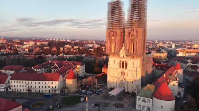 Aerial view of Zagreb Cathedral and the historic Kaptol district. Cinematic drone shot of the Gothic spires and the medieval walls of the Cathedral of the Assumption of the Blessed Virgin Mary in Croa