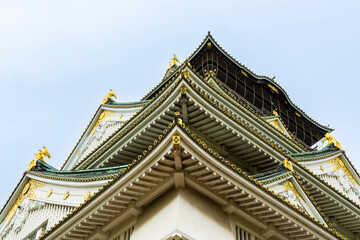Obraz premium Intricate roofline of the historic Osaka Castle in Spring, low angle view