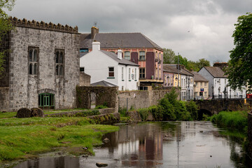 Fototapeta premium Historic Riverside Townscape in Ireland With Stone Buildings and Bridge, Scenic Urban Landscape