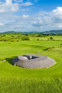 Aerial view of Carrowmore Passage Tomb surrounded by bright green fields in County Sligo, Ireland. An ancient megalithic monument in the Irish countryside.