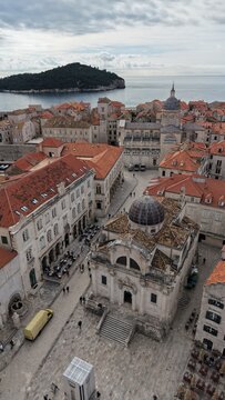 Aerial view of Dubrovnik Old Town and its medieval city walls. Cinematic shot of the UNESCO World Heritage site featuring limestone streets and terracotta roofs in Croatia.