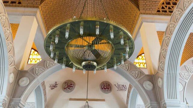 Cinematic view of the intricate brick dome and elegant chandeliers inside the historic Al-Mustarah Mosque in Medina.