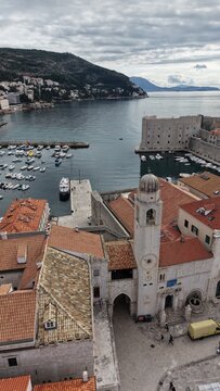 Aerial view of Dubrovnik Old Town and its medieval city walls. Cinematic shot of the UNESCO World Heritage site featuring limestone streets and terracotta roofs in Croatia.