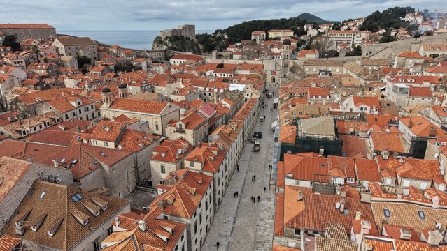 Aerial view of Dubrovnik Old Town and its medieval city walls. Cinematic shot of the UNESCO World Heritage site featuring limestone streets and terracotta roofs in Croatia.