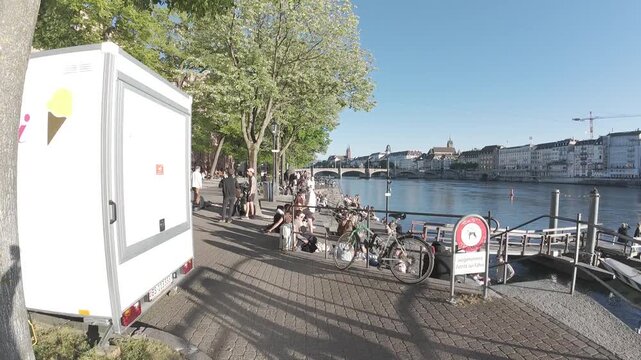 Hyperlapse walking along the Rhine river promenade with bicycles, bridge and old town skyline in Basel, Switzerland