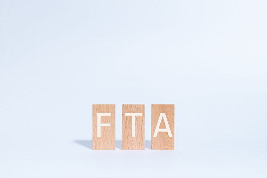Eye-catching image of FTA text on wood blocks. The word stands for Free Trade Agreement.