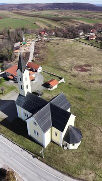 aerial view of St. Anthony of Padua Church in Dreznik Grad. Cinematic drone orbit of a historic Catholic church in the Croatian countryside near Plitvice Lakes