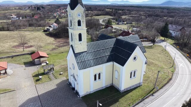 aerial view of St. Anthony of Padua Church in Dreznik Grad. Cinematic drone orbit of a historic Catholic church in the Croatian countryside near Plitvice Lakes