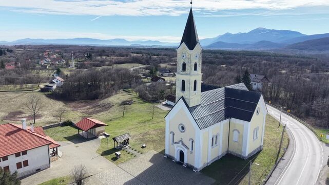 aerial view of St. Anthony of Padua Church in Dreznik Grad. Cinematic drone orbit of a historic Catholic church in the Croatian countryside near Plitvice Lakes