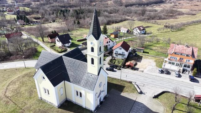 aerial view of St. Anthony of Padua Church in Dreznik Grad. Cinematic drone orbit of a historic Catholic church in the Croatian countryside near Plitvice Lakes