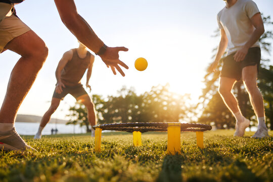 Friends Playing Spikeball Outdoors at Sunset in Park