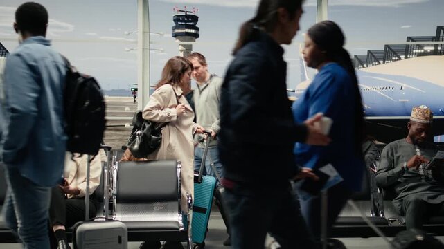 Upset woman in airport scolding man after bumping trolley into her while hurrying to catch plane. Angry tourist yelling at traveler for bashing her luggage in busy departure terminal, camera A