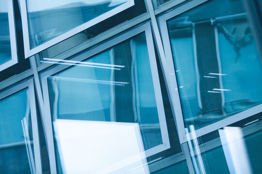 Open windows with beautiful reflections of the modern business centre made of glass. Urban futuristic style. Outdoor shot