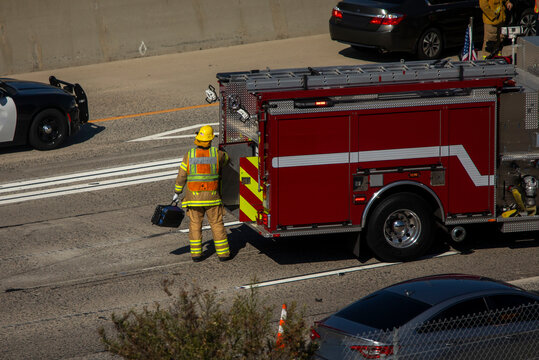  Above View of emergency vehicles including fire trucks and a firefighter on a freeway of a major accident