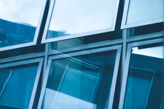 Open windows with beautiful reflections of the modern business centre made of glass. Urban futuristic style. Outdoor shot