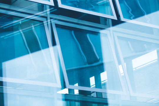 Open windows with beautiful reflections of the modern business centre made of glass. Urban futuristic style. Outdoor shot
