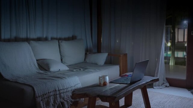 Thief breaking into a dark house to steal a laptop at night