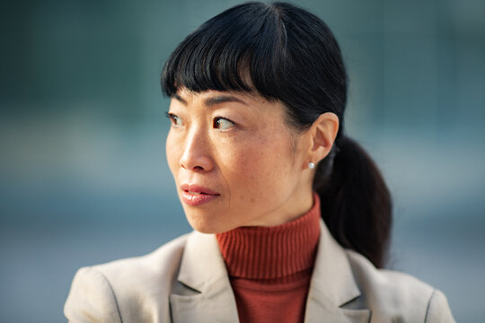 Confident businesswoman in blazer looking sideways outdoors