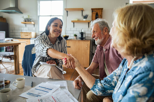 Financial advisor meeting senior couple in home kitchen