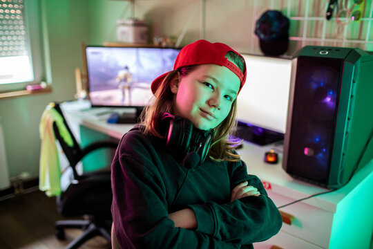Confident kid gamer with headset at home gaming pc
