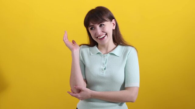 Happy woman laughing at joke on yellow background