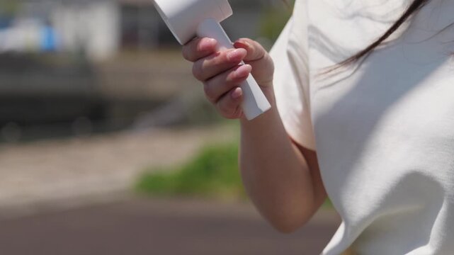 バッグからハンディ扇風機を取り出す女性 | 外出先での暑さ対策