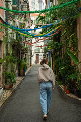 Obraz premium Woman walk through a charming, narrow street