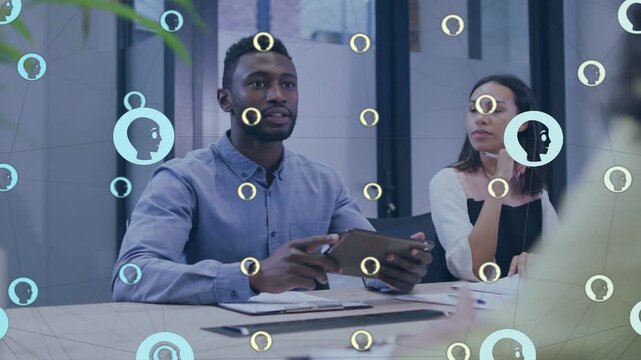 Two interviewers at table, man holding tablet shaking new guest's hand as avatars overlay faces