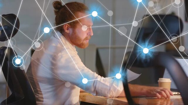 Businessman checking watch, reviewing laptop papers while network overlay briefly obscuring man