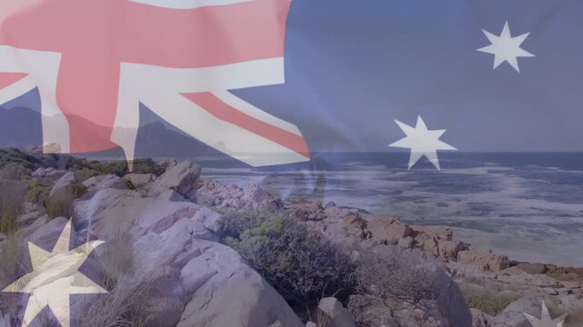 On start Australian flag rippling over rocky headland, revealing coastline, symbolizing identity