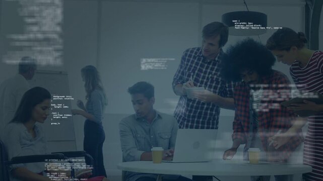 Seated engineer starting laptop, team leaning in at table reviewing app with floating code overlay
