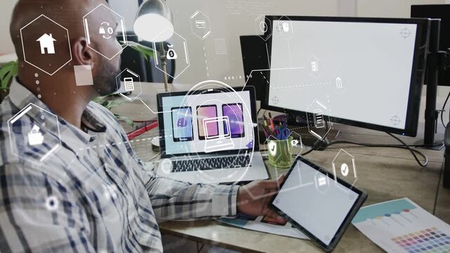 Designer comparing tablet laptop monitor while hex HUD fading in spurring layout review for design
