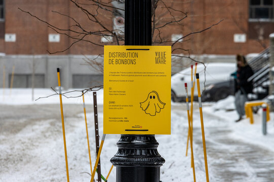 MONTREAL, CANADA, 25 December 2025 : distribution de bonbons ville marie affiche jaune fantome neige trottoir rue