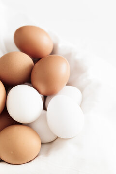 Colorful eggs nestled softly in a white cloth basket create a charming kitchen moment during a sunny morning