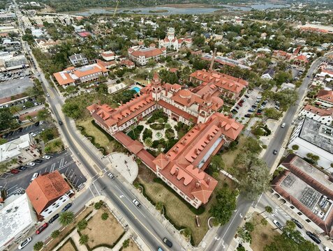 Aerial view of Flagler College featuring its iconic red-tiled roofs and Spanish Renaissance architecture surrounded by historic streets and lush greenery in St. Augustine, Florida, United States.