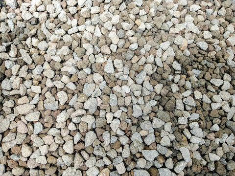 Top view of natural grey gravel stones texture. Small crushed rocks background for construction or gardening