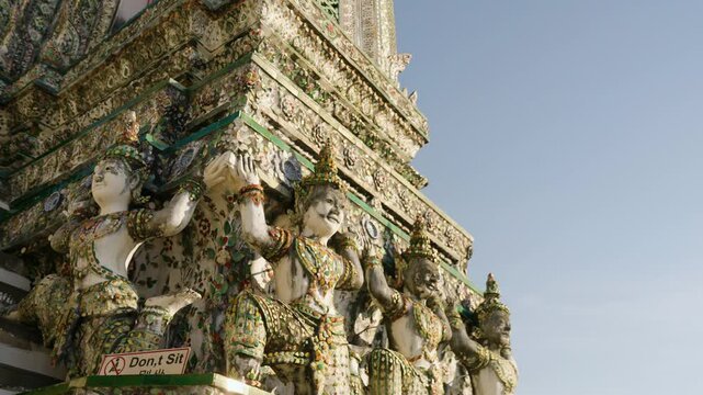 Yaksha Sculptures At The Base Of Tiered Buddha Stupa At Wat Arun Temple In Bangkok, Thailand. close-up, orbiting shot