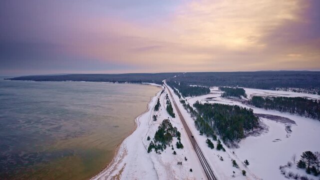 Drone shot flying along desolate US highway 2 in Northern Michigan with Lake superior