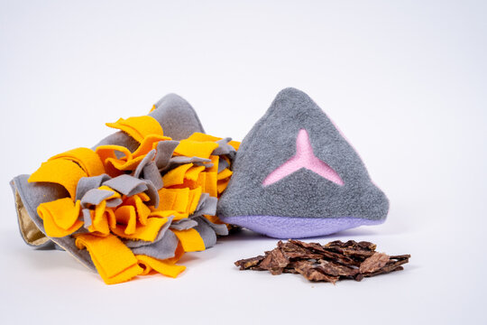 Handmade felt snuffle mat enrichment toy in yellow and gray with dried meat treat piece on white background, interactive pet mental stimulation product.