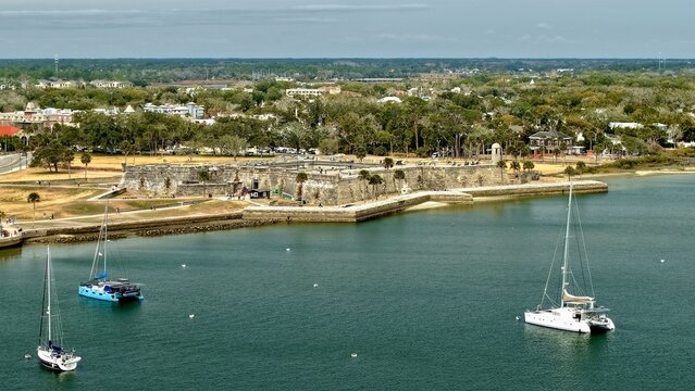 Aerial view of Castillo de San Marcos historic fort with sailboats on the Matanzas River and lush green trees in St. Augustine, Florida, United States.
