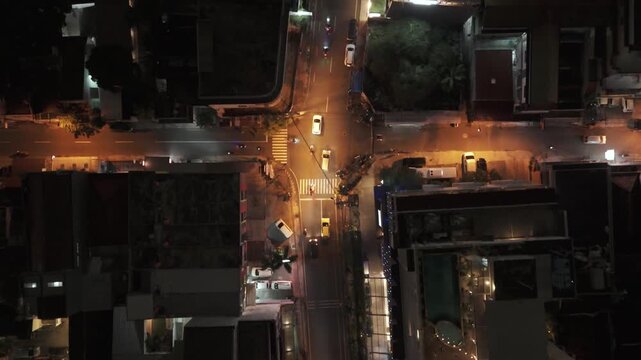 Aerial: Yogyakarta street at night with lights and traffic in Indonesia, Asia, top down drone shot