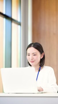 パソコンの仕事をするタイピングするオフィスカジュアルな女性の縦動画のイメージ